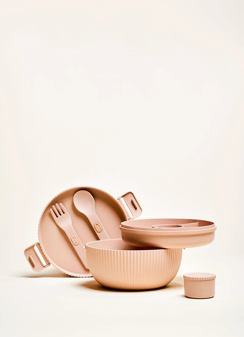 Beige bioloco Deluxe bowl aus pflanzenbasiertem PLA. Geöffnet mit integriertem Teller, Gabel und Löffel, kleiner Salatsoßenbox