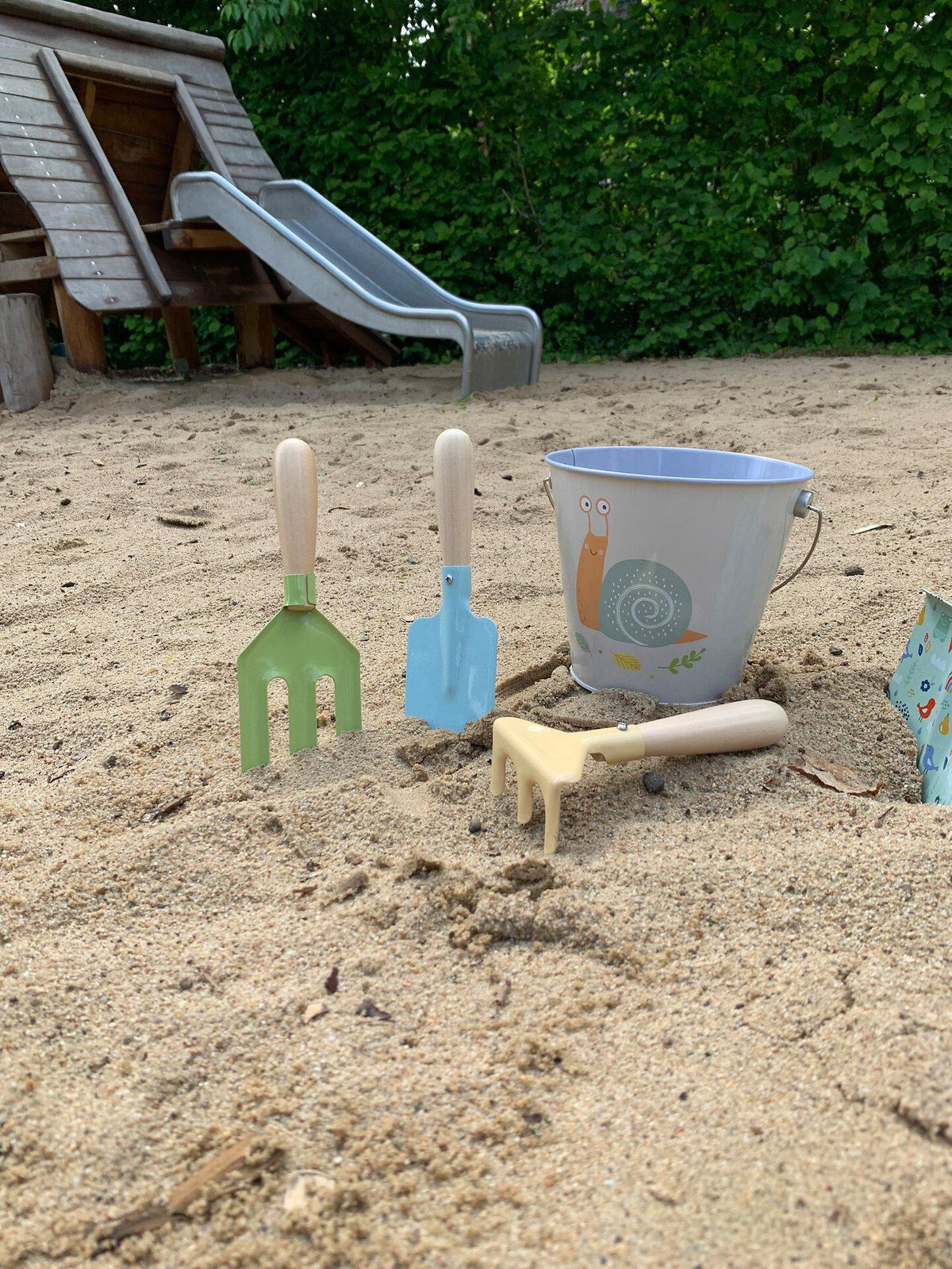 Eimer mit Schneckenmotiv und drei Gartenwerkzeugen – Ansicht