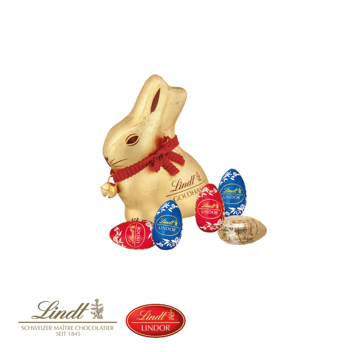 Goldhase mit Glöckchen und fünf Schokoladeneier von Lindt im Ostergras
