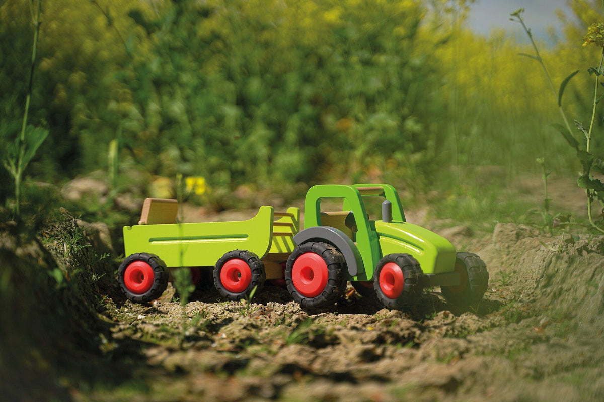 Holztraktor in Grün mit Heuwagen und roten Rädern – weitere Ansicht