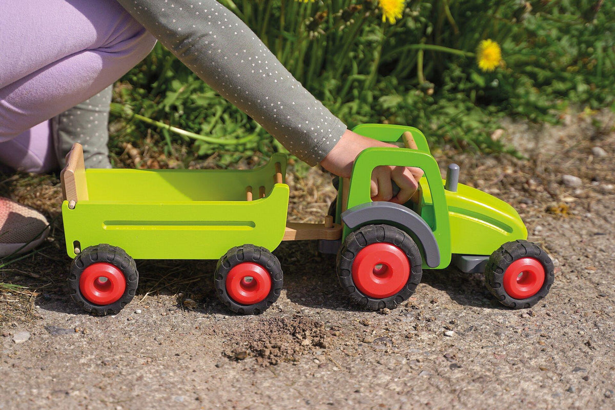 Holztraktor in Grün mit Heuwagen und roten Rädern – weitere Ansicht