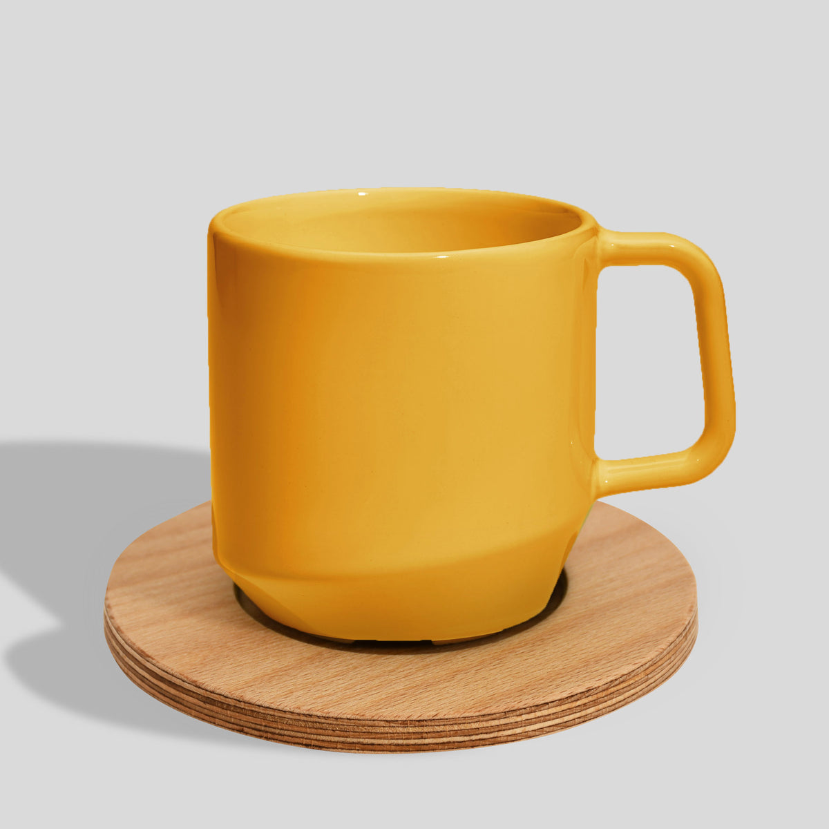Keramiktasse 400 ml mit Eckhenkel auf Holzuntersetzer – Gelb