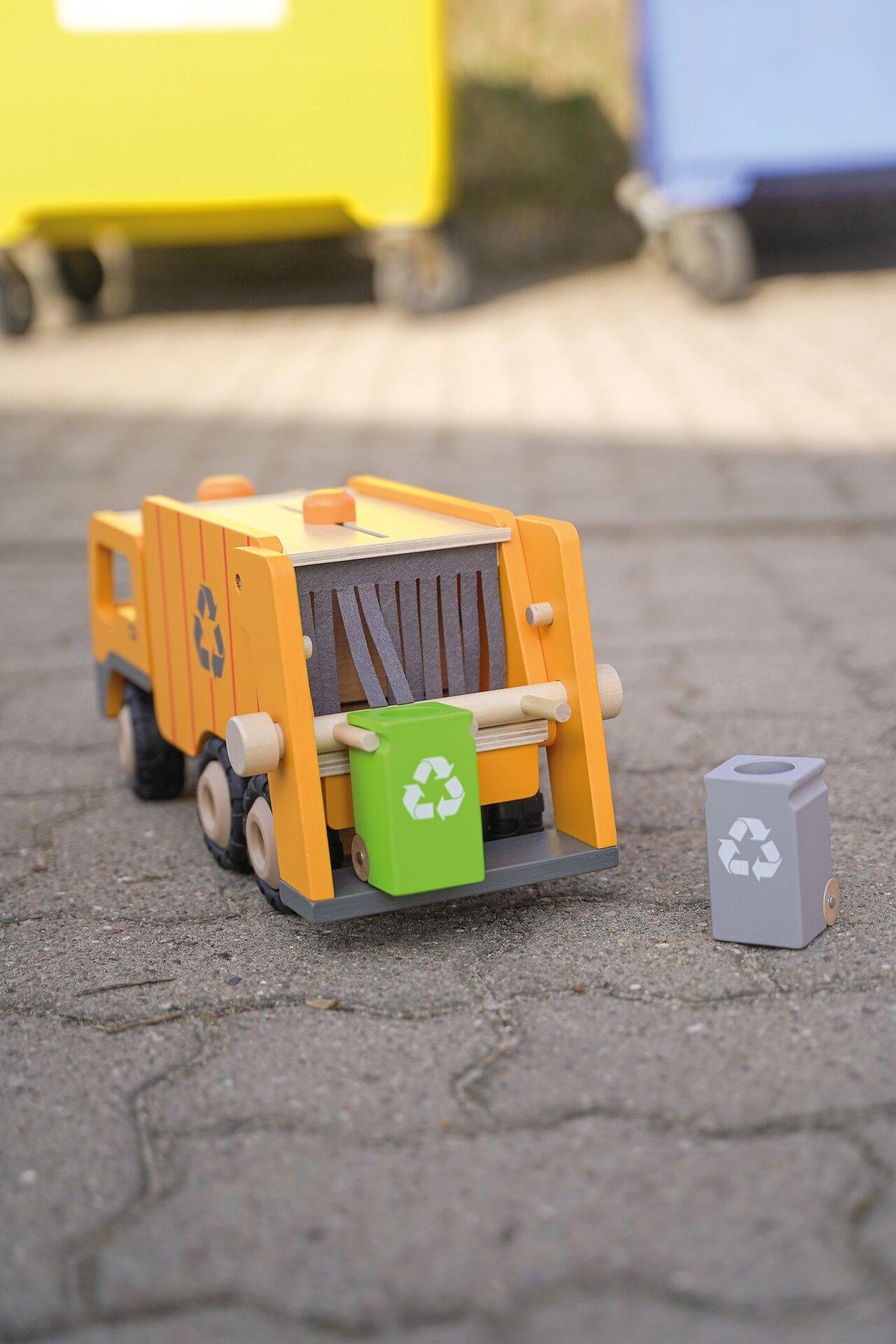 Müllwagen aus Holz in Orange mit zwei Mülltonnen – Nahaufnahme