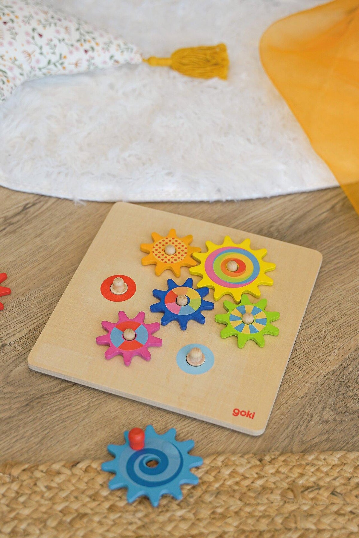 Zahnradspiel mit bunten Drehscheiben auf Holzbrett – weitere Ansicht